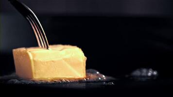 Super slow motion a piece of butter with a fork melts in a frying pan. Filmed on a high-speed camera at 1000 fps. High quality FullHD footage video