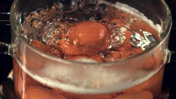 super langzaam beweging eieren zijn gekookt in koken water met lucht bubbels. Aan een zwart achtergrond. gefilmd Aan een hoge snelheid camera Bij 1000 fps. video