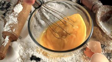 Super slow motion the man's hand whisk stirs the eggs for baking. On a white background.Filmed on a high-speed camera at 1000 fps. video