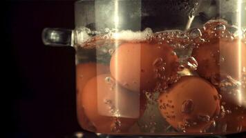 Super slow motion eggs are boiled all over by air bubbles in the pan. On a black background.Filmed on a high-speed camera at 1000 fps. video