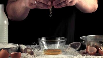 Super slow motion hands cooks break the egg for baking. On a black background. Filmed on a high-speed camera at 1000 fps. video