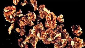 un pila de nueces se sienta en un negro fondo, parecido a un flor acuerdo. estos nueces lata ser usado en varios recetas a crear delicioso platos video