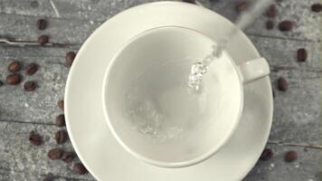 Super slow motion in the mug pours a stream of water. On a gray background. Filmed on a high-speed camera at 1000 fps. video