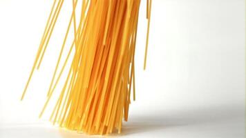 Super slow motion pasta spaghetti dry falls on the table. On a white background. Filmed on a high-speed camera at 1000 fps. High quality FullHD footage video