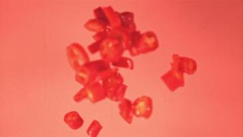 Super slow motion sliced red chilli pepper falls on the water with splashes. On a pink background.Filmed on a high-speed camera at 1000 fps. High quality FullHD footage video