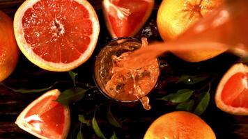 Super slow motion fresh grapefruit juice pours into the glass. Against a dark background.Filmed on a high-speed camera at 1000 fps. Top view. video