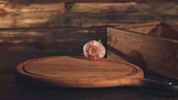 Super slow motion garlic falls on a cutting board on a wooden background. Filmed on a high-speed camera at 1000 fps. High quality FullHD footage video