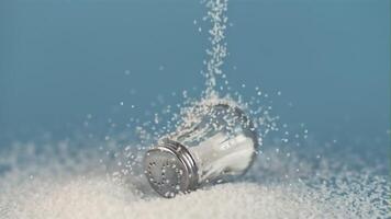 Super slow motion drop salt on a salt shaker, on a blue background. Filmed on a high-speed camera, 1000 fps. video