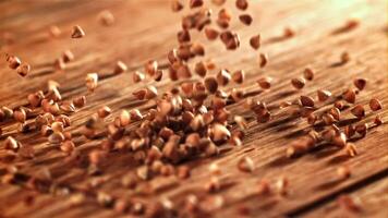 Buckwheat falling on a wooden board. Filmed on a high-speed camera at 1000 fps. High quality FullHD footage video