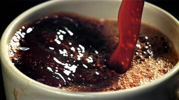 Black coffee pours into a cup. Filmed on a high-speed camera at 1000 fps. High quality FullHD footage video