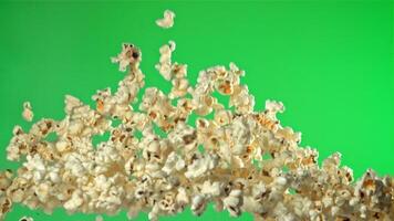 Popcorn flies up and falls down. On a green background. Filmed on a high-speed camera at 1000 fps. High quality FullHD footage video