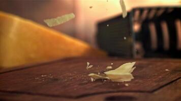 Parmesan cheese falls on a wooden board. Filmed on a high-speed camera at 1000 fps. High quality FullHD footage video