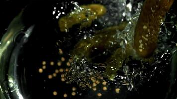 Pickled cucumbers fall with splashes. Filmed on a high-speed camera at 1000 fps. High quality FullHD footage video