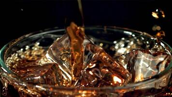 Cola is poured into a glass with ice. Filmed is slow motion 1000 fps. High quality FullHD footage video