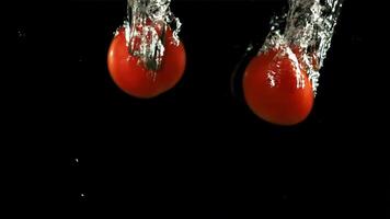 Tomatoes fall under water. Filmed is slow motion 1000 fps. High quality FullHD footage video