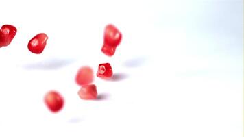 Super slow motion pomegranate grains fall on the table. On a white background.Filmed on a high-speed camera at 1000 fps. High quality FullHD footage video