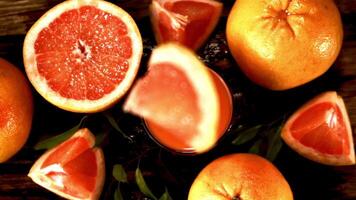 Super slow motion with splashes a piece of grapefruit falls into a glass of juice. Filmed on a high-speed camera at 1000 fps.On a wooden background. Top view. video