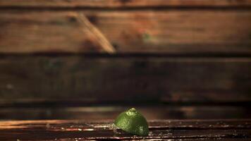 Super slow motion pieces of fresh lime fall on the table. On a wooden background.Filmed on a high-speed camera at 1000 fps. video