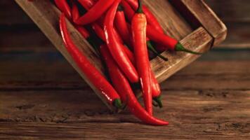 Super slow motion wooden tray with red pepper falls on the table. On a wooden background. Filmed on a high-speed camera at 1000 fps. High quality FullHD footage video