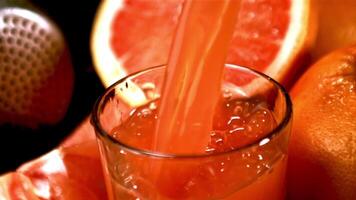 Super slow motion grapefruit juice pours into the glass over the edge. Filmed on a high-speed camera at 1000 fps.Macro background. video