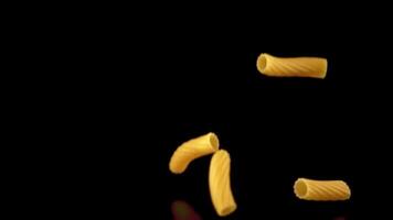 Super slow motion of the dry cannelloni pasta drops. On a black background. Filmed on a high-speed camera at 1000 fps.High quality FullHD footage video