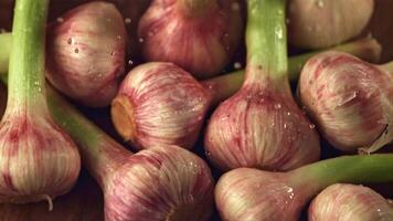 Super slow motion water droplets fall on the garlic. On a wooden background.Filmed on a high-speed camera at 1000 fps. High quality FullHD footage video