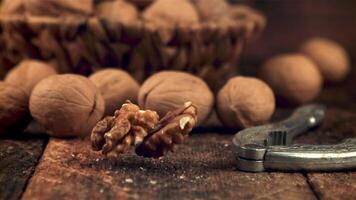 super lento movimento di noce cereali autunno su il tavolo. su un' di legno sfondo. girato su un' alta velocità telecamera a 1000 fps. video