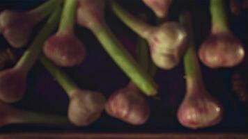 Super slow motion tray with garlic falls on a wooden table. Filmed on a high-speed camera at 1000 fps. High quality FullHD footage video