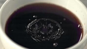 Super slow motion in the mug with coffee drops a drop with splashes. Macro background. Filmed on a high-speed camera at 1000 fps. video