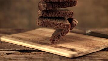 Super slow motion on the cutting board fall pieces of bread. Against a dark background. Filmed on a high-speed camera at 1000 fps. video