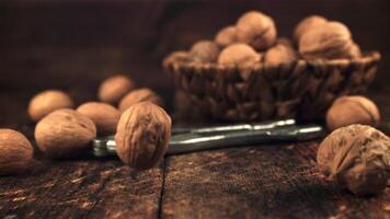 Super slow motion a lot of walnuts falls on the table. On a wooden background. Filmed on a high-speed camera at 1000 fps.High quality FullHD footage video