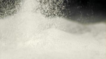 Super slow motion flour is poured onto the baking table. On a black background. Filmed on a high-speed camera at 1000 fps. video