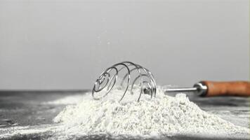 Super slow motion whisk falls on the table in a pile of flour. On a white background. Filmed on a high-speed camera at 1000 fps.High quality FullHD footage video