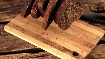 super langzaam beweging Aan een houten snijdend bord druppels brood. Aan een houten achtergrond.gefilmd Aan een hoge snelheid camera Bij 1000 fps. video