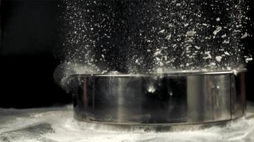 Super slow motion on the table drops a sieve with flour. On a black background. Filmed on a high-speed camera at 1000 fps.High quality FullHD footage video