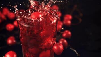 Super schleppend Bewegung im ein Glas von Saft Tropfen Kirsche mit Spritzer. auf ein schwarz Hintergrund. gefilmt auf ein schnelle Geschwindigkeit Kamera beim 1000 fps. video