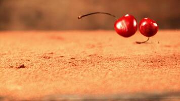 Super slow motion fresh cherry falls on the table with cocoa. On a brown background. Filmed on a high-speed camera at 1000 fps. video