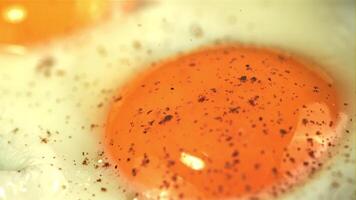 Super slow motion ground pepper falls on the fried egg. Macro background. Filmed on a high-speed camera at 1000 fps. video