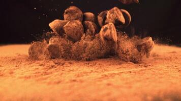 Super slow motion truffles fall into the cocoa. On a black background. Filmed on a high-speed camera at 1000 fps.High quality FullHD footage video