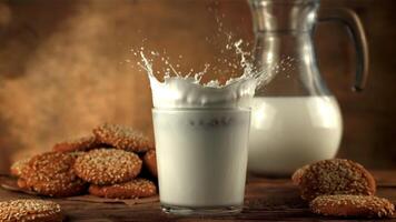 Super slow motion oatmeal cookies falls into a glass of milk with spray. On a brown background.Filmed on a high-speed camera at 1000 fps. video