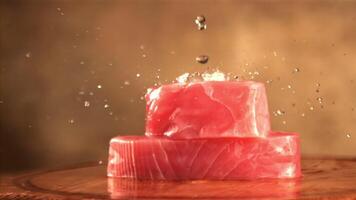 Super slow motion on raw tuna steaks drops water. On a brown background. Filmed on a high-speed camera at 1000 fps.High quality FullHD footage video