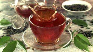 Super slow motion in a cup of tea drops a piece of sugar with splashes. On a gray background. Filmed on a high-speed camera at 1000 fps. video