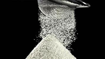 The flour is sifted through a sieve. On a black background. Filmed on a high-speed camera at 1000 fps. High quality FullHD footage video