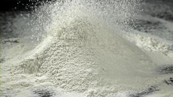 The flour is sifted onto a mound with flour. Filmed on a high-speed camera at 1000 fps. High quality FullHD footage video