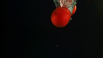 Tomatoes fall under water. Filmed is slow motion 1000 fps. High quality FullHD footage video