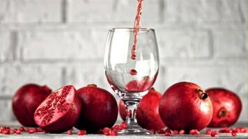 Super slow motion of the rocket of pomegranate juice pours into the glass. On a white background. Filmed on a high-speed camera at 1000 fps. High quality FullHD footage video