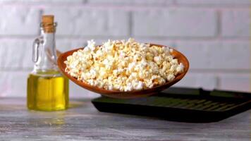 een super langzaam beweging bord met popcorn valt Aan de tafel. Aan een wit achtergrond. gefilmd Aan een hoge snelheid camera Bij 1000 fps. hoog kwaliteit full HD beeldmateriaal video