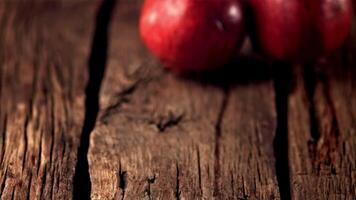 Super slow motion ripe pomegranats roll down wooden boards. On a wooden background. Filmed on a high-speed camera at 1000 fps. High quality FullHD footage video