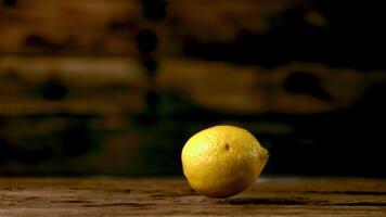 Super slow motion fresh lemons fall on the wooden table. On a wooden background.Filmed on a high-speed camera at 1000 fps. High quality FullHD footage video