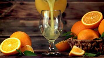 Super slow motion from the jug into the glass pour orange juice. Filmed on a high-speed camera at 1000 fps.On a wooden background. video